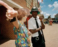 two people standing on a street corner pointing at something