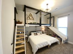 a bed sitting under a window next to a stair case in a room with carpeted flooring