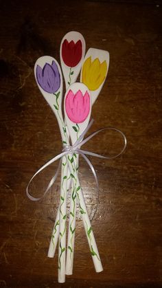 three paper flowers are tied together on a table