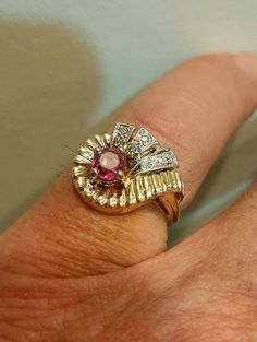 Offering a wonderful ruby and diamond mid-century style gold ring. The bright clean, natural ruby weighs .75 carats. The nice clean diamonds are .12 carat total. The ring is 2 tone solid 14 karat gold weighing 4.3 grams. It is 13 x 16mm across The ring is solid showing little to no wear all settings secure Currently size 6 and can be sized please inquire. Collectible Ruby Ring With Diamond, Vintage Ruby Ring With Diamond Accents, Collectible Ruby Ring With Diamond Setting, Collectible Yellow Gold Ruby Ring With Diamonds, Collectible Ruby Ring In Yellow Gold, Round Cut Diamond Ruby Ring Stamped 14k, Ruby And Diamond Ring Stamped 14k, 14k Diamond Ruby Ring With Round Cut, Vintage Pink Ruby Ring With Diamonds