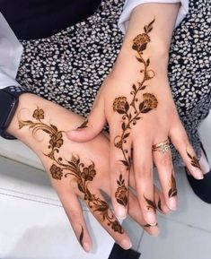 two hands with henna tattoos on them