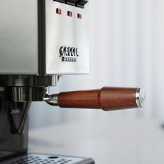 an espresso machine is being operated by a wood handle