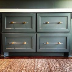 a gray dresser with gold handles and drawers