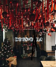 a room filled with lots of christmas decorations and hanging balls above the fireplace in front of a sign that says dogstails