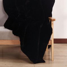 a black blanket sitting on top of a wooden chair