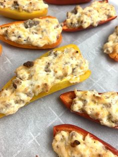 stuffed bell peppers with cheese on them sitting on a baking sheet, ready to go into the oven