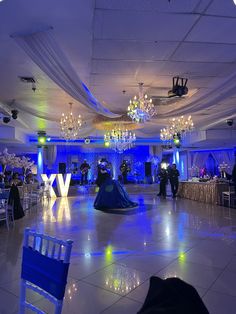 the dance floor is decorated with blue lights and chandeliers