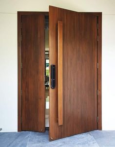 an open wooden door in front of a white wall