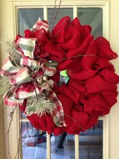 a red wreath is hanging on the front door