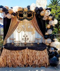 a black, gold and white birthday party with balloons on the side of the table