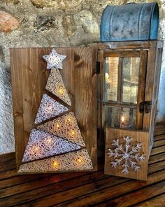 a wooden box with a christmas tree cut out of it next to a candle holder