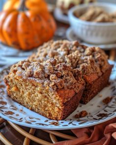 two pieces of cake sitting on top of a blue and white plate next to some pumpkins