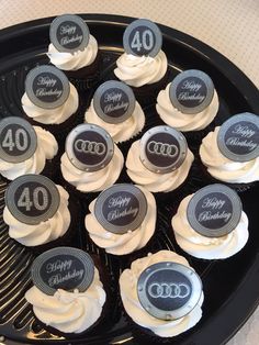 cupcakes with white frosting and black icing are arranged in a circle