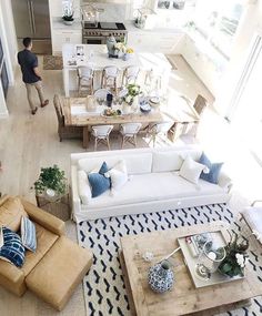 an overhead view of a living room and kitchen area with couches, chairs, coffee table