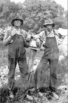 two men standing next to each other in the grass