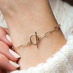 A modern paperclip chain bracelet made entirely from 14k gold fill. An effortless piece to wear with any outfit. Featuring a T-bar clasp and sturdy paperclip chain, this piece is available in a range of sizes for the perfect fit. The paperclip chain bracelet is made in our Leicestershire studio and presented in a bespoke Minetta box, ready for gifting. About Gold Fill: 14k gold filled jewellery has 100+ times more gold than gold plated. Composed of a solid layer of gold bonded with heat and pres Minimalist Paperclip Bracelet With Adjustable Chain, 14k Gold Filled Paperclip Link Bracelet With Delicate Chain, Everyday Gold-tone Paperclip Bracelet With Lobster Clasp, Gold-tone Paperclip Bracelet With Lobster Clasp, Modern Gold-tone Paperclip Bracelet With Rectangular Links, Modern Gold-tone Link Paperclip Bracelet, Classic Everyday Gold-tone Paperclip Bracelet, Modern Gold Chain Paperclip Bracelet With Rectangular Links, Modern Paperclip Bracelet With Rectangular Gold Links