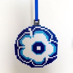 a cross stitch ornament with an eyeball design on it's side