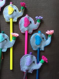 four felt elephant pencils and two elephants on top of each other with different colors