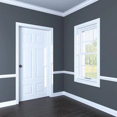 an empty room with gray walls and white trim on the doors, windows and wood flooring