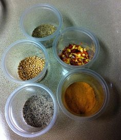 four bowls filled with different types of spices