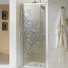 a bathroom with a glass shower door next to a towel rack and pictures on the wall