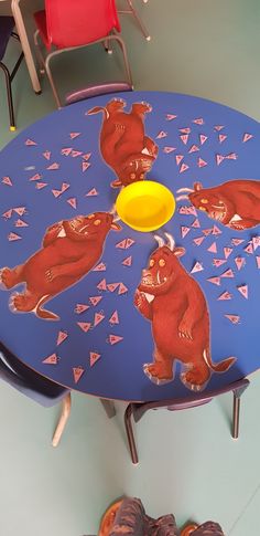 there is a blue table with red bears on it and a yellow frisbee