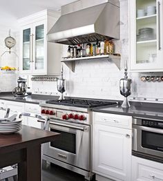 a kitchen with white cabinets and stainless steel appliances