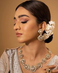 a woman wearing an elaborate necklace and earrings