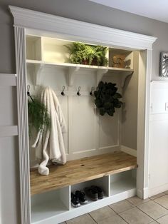 a white coat rack filled with shoes and plants