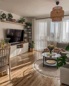 a living room filled with furniture and a flat screen tv on top of a wooden floor