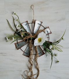 a windmill with flowers tied to it on the wall next to a tile flooring