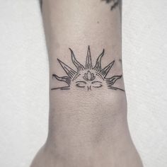 a small sun tattoo on the ankle