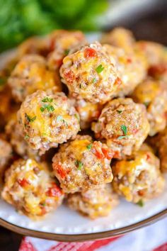 a white plate topped with meatballs covered in cheese and seasoning next to broccoli