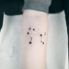 a person with a tattoo on their arm that has stars and the moon in it