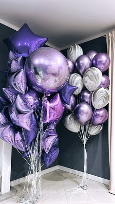 purple and silver balloons are on display in a room