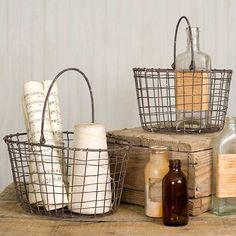 three metal baskets sitting on top of a wooden table next to bottles and paper towels