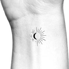 a black and white photo of a sun and moon tattoo on the left side of someone's arm