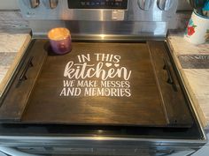 a wooden tray with the words in this kitchen we make messes and memories on it