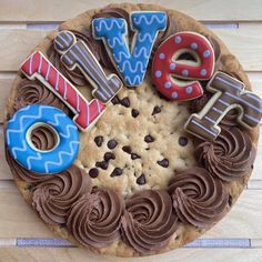 a cookie with chocolate frosting and decorated cookies in the shape of letters that spell out love