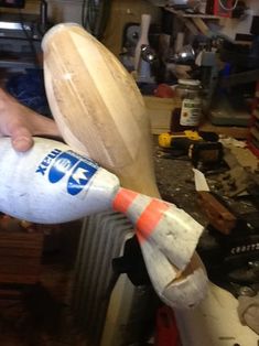 a person holding a wooden object in their hand and making it look like a rocket ship