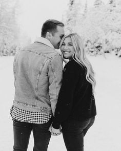 a man and woman standing next to each other in the snow