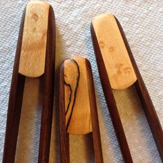 three wooden spoons sitting next to each other on top of a white cloth covered floor