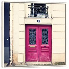 two red doors with wrought iron grills in front of a building