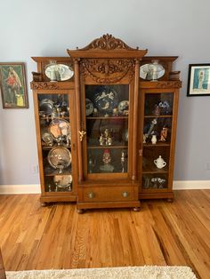 an antique china cabinet with glass doors on the front and sides, in a living room