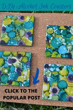 four square coasters sitting on top of a cork board covered in blue and green paint