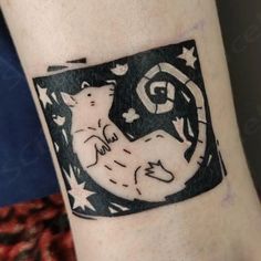 a tattoo on the arm of a person with a cat and moon in the background