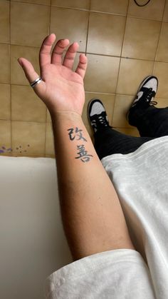 a person's arm with chinese writing on it and their hand in the air