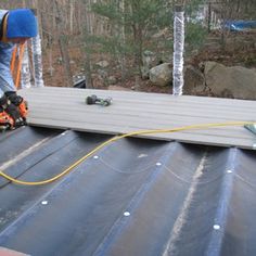 a man working on the roof of a house with a power drill and an electric saw