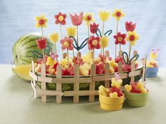 there is a cake made to look like flowers and fruit in the shape of baskets