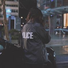 a police officer sitting on the back of a car in front of a tall building